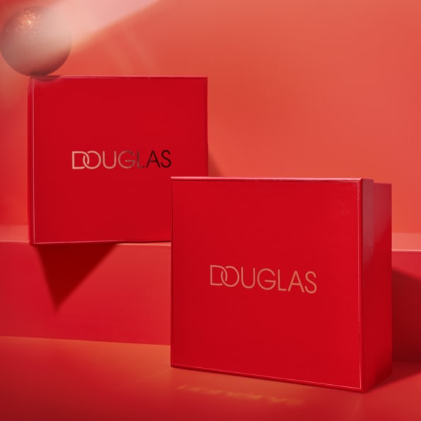 Dwa czerwone pudełka Douglas z logo w kolorze srebra, ustawione na czerwonym tle, tworzą elegancką kompozycję.