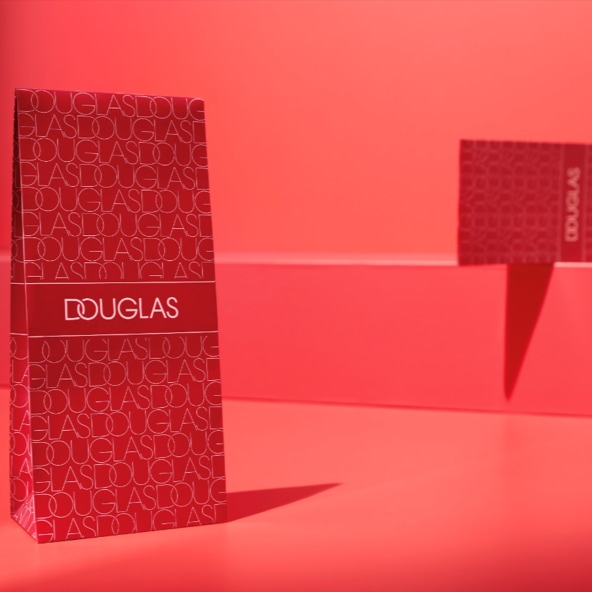 Czerwone pudełko Douglas z powtarzającym się napisem Douglas na tle w tym samym kolorze.