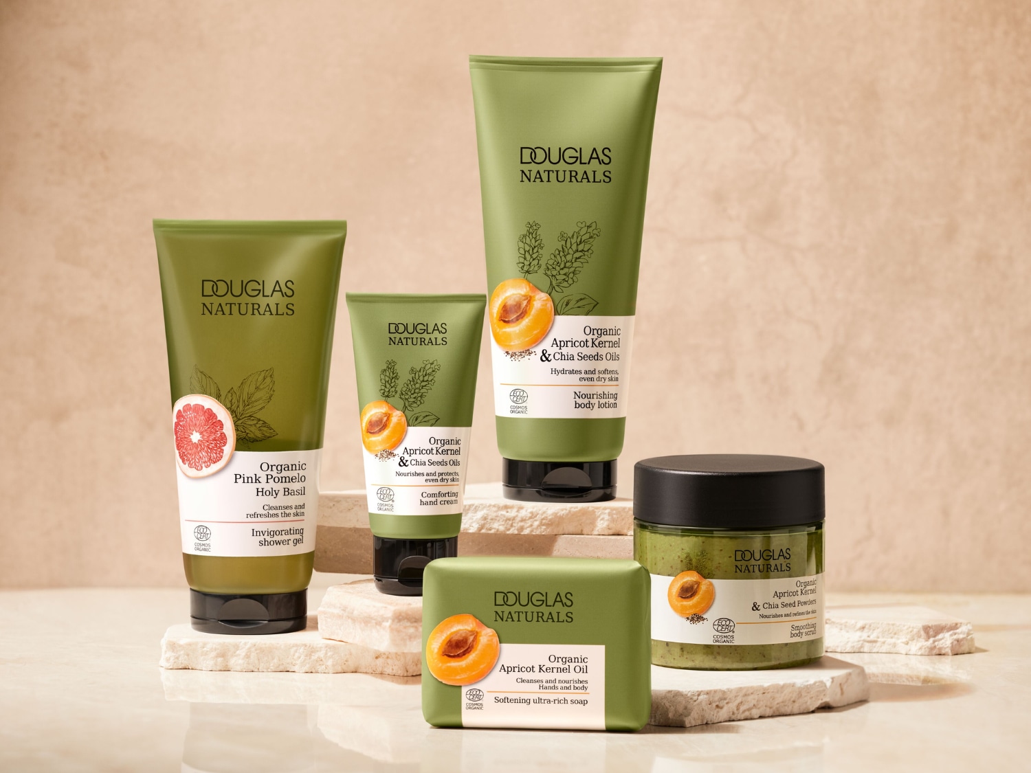 Kolekcja Douglas Naturals zawiera żel pod prysznic z różowego pomelo i bazylii, balsam do ciała z pestek moreli i olejków z nasion chia, krem do rąk, mydło w kostce oraz wygładzający peeling do ciała, wszystkie w zielonych opakowaniach z naturalnymi składnikami.