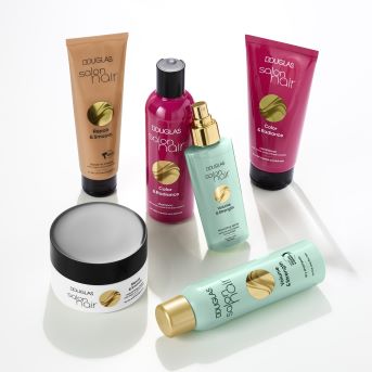 Verschiedene Douglas Salon Hair Produkte in Gold-, Pink- und Türkistönen für Reparatur, Farbe und Volumen.