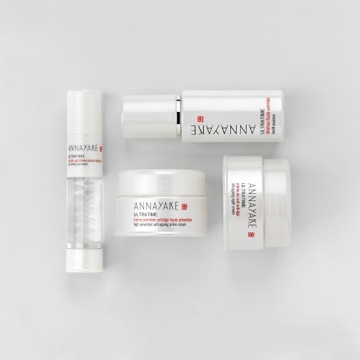 Die ANNAYAKE Ultratime-Kollektion umfasst eine straffende Augencreme, ein revitalisierendes Fluid und eine Anti-Aging-Creme in schlichten, weißen Verpackungen.