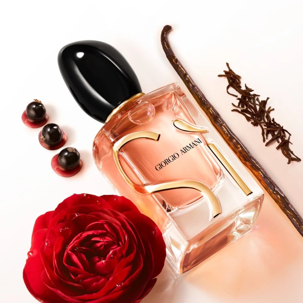 Een flacon Giorgio Armani parfum met gouden details, zwarte dop, rode roos, vanille stokje en zwarte bessen.