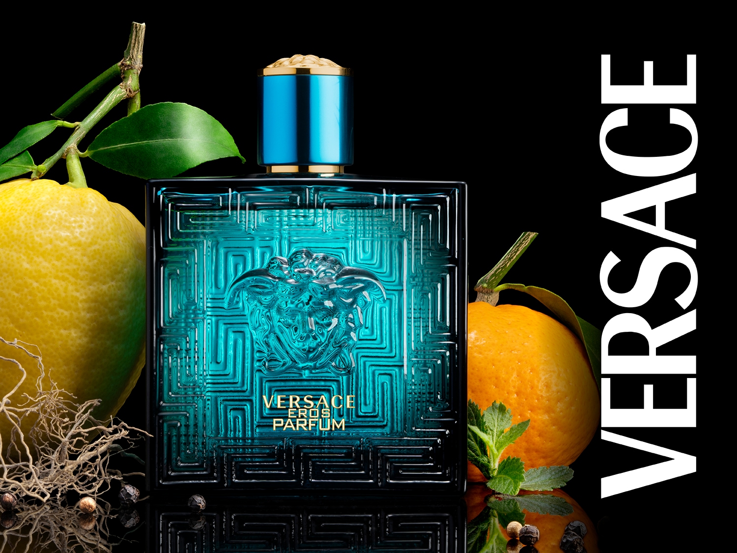 Butelka perfum Versace Eros Parfum w turkusowym szkle z greckim wzorem, otoczona cytryną i pomarańczą na czarnym tle, emanuje świeżością i luksusem.