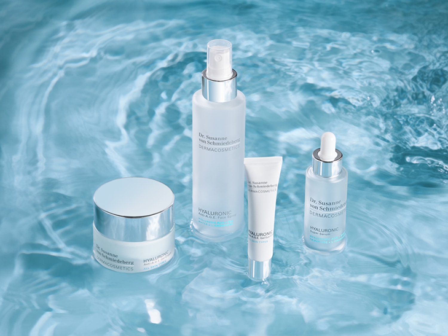 A Dr. Susanne von Schmiedeberg DERMACOSMETICS termékekből álló kollekció kék vízen lebeg, beleértve a HYALURONIC Anti-A.G.E. krémet, arcpermetet és szérumot.