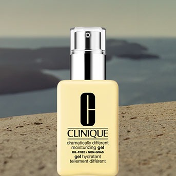 Żółty żel nawilżający Clinique Dramatically Different Oil-Free w przezroczystej butelce z srebrną pompką na tle morza.