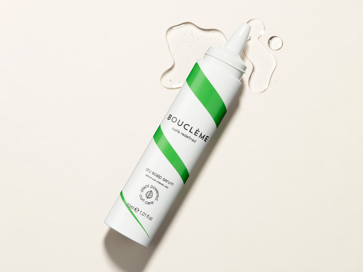 Voici un sérum pour cuir chevelu sec Bouclème dans un tube blanc avec une bande verte en diagonale, conçu pour redéfinir les boucles et hydrater le cuir chevelu.