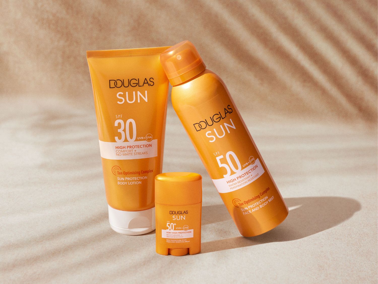A Douglas Sun termékcsalád narancssárga csomagolásban: SPF 30 napvédő testápoló, SPF 50 arc- és testpermet, valamint SPF 50+ stift a nagyon magas védelemért.