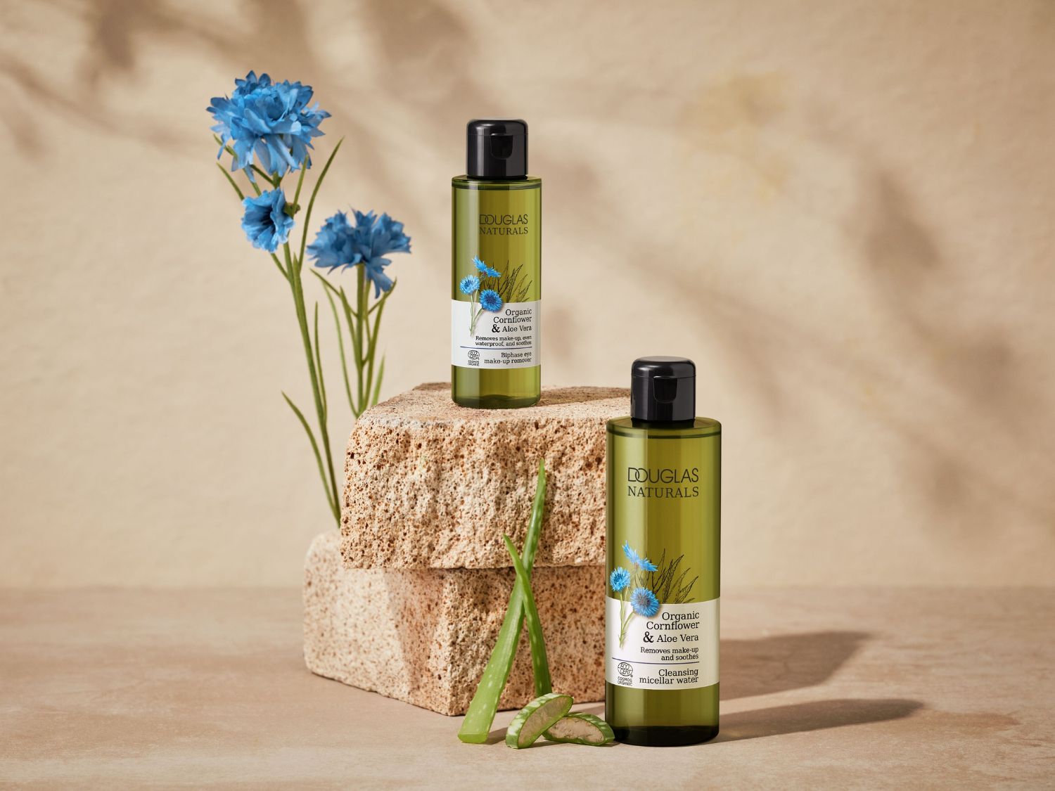 A Douglas Naturals organikus kukoricavirág és aloe vera termékei láthatók, beleértve a kétszakaszos szemfestéklemosót és a micellás tisztítóvizet, zöld színű csomagolásban.