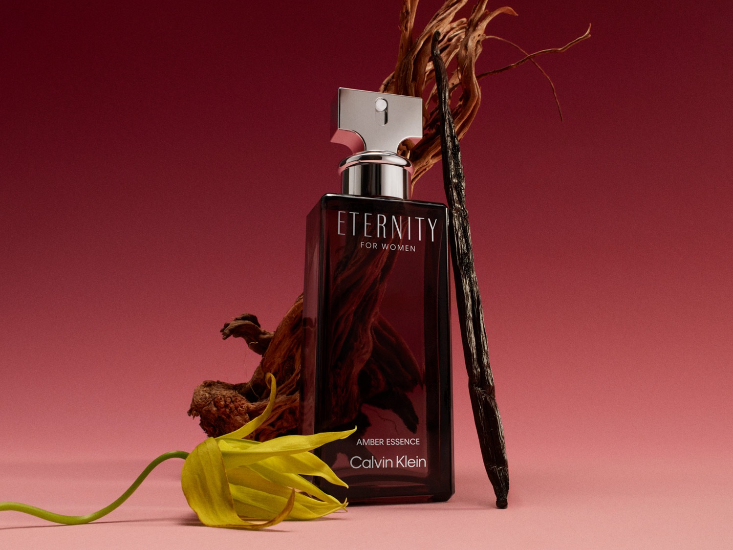 Hnědý flakon parfému Eternity for Women od Calvina Kleina s dřevitými tóny a žlutým květem.