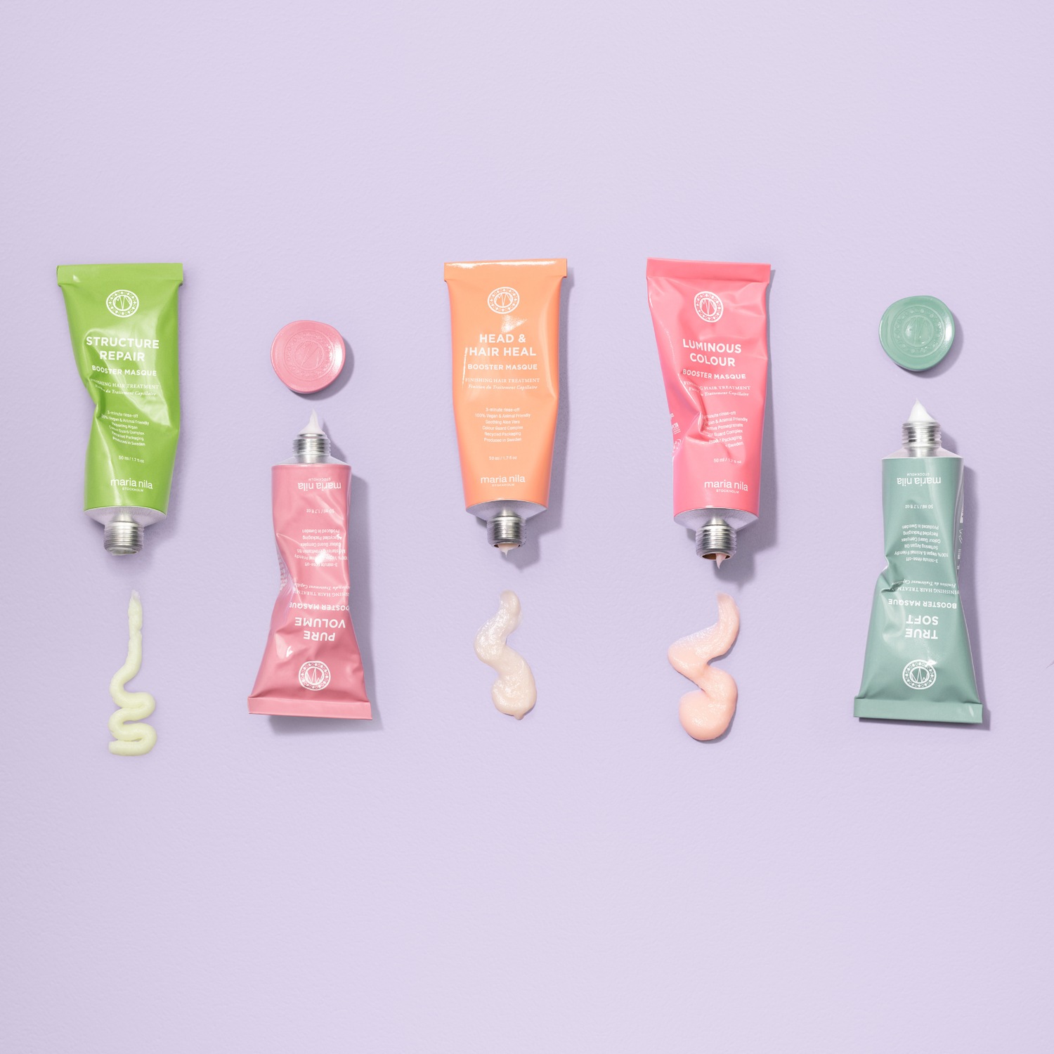 Verschiedenfarbige Tuben von Maria Nila Haarmasken, darunter Structure Repair in Grün, Head & Hair Heal in Orange, Luminous Colour in Pink, Pure Volume in Rosa und True Soft in Grün.