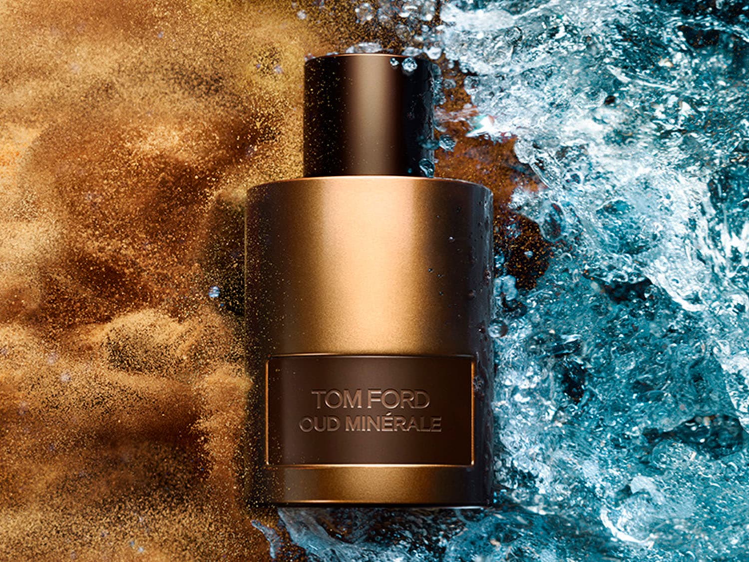 El frasco cilíndrico dorado de Tom Ford Oud Minérale se destaca entre un fondo de arena dorada y agua azul cristalina, evocando una sensación de lujo y frescura.