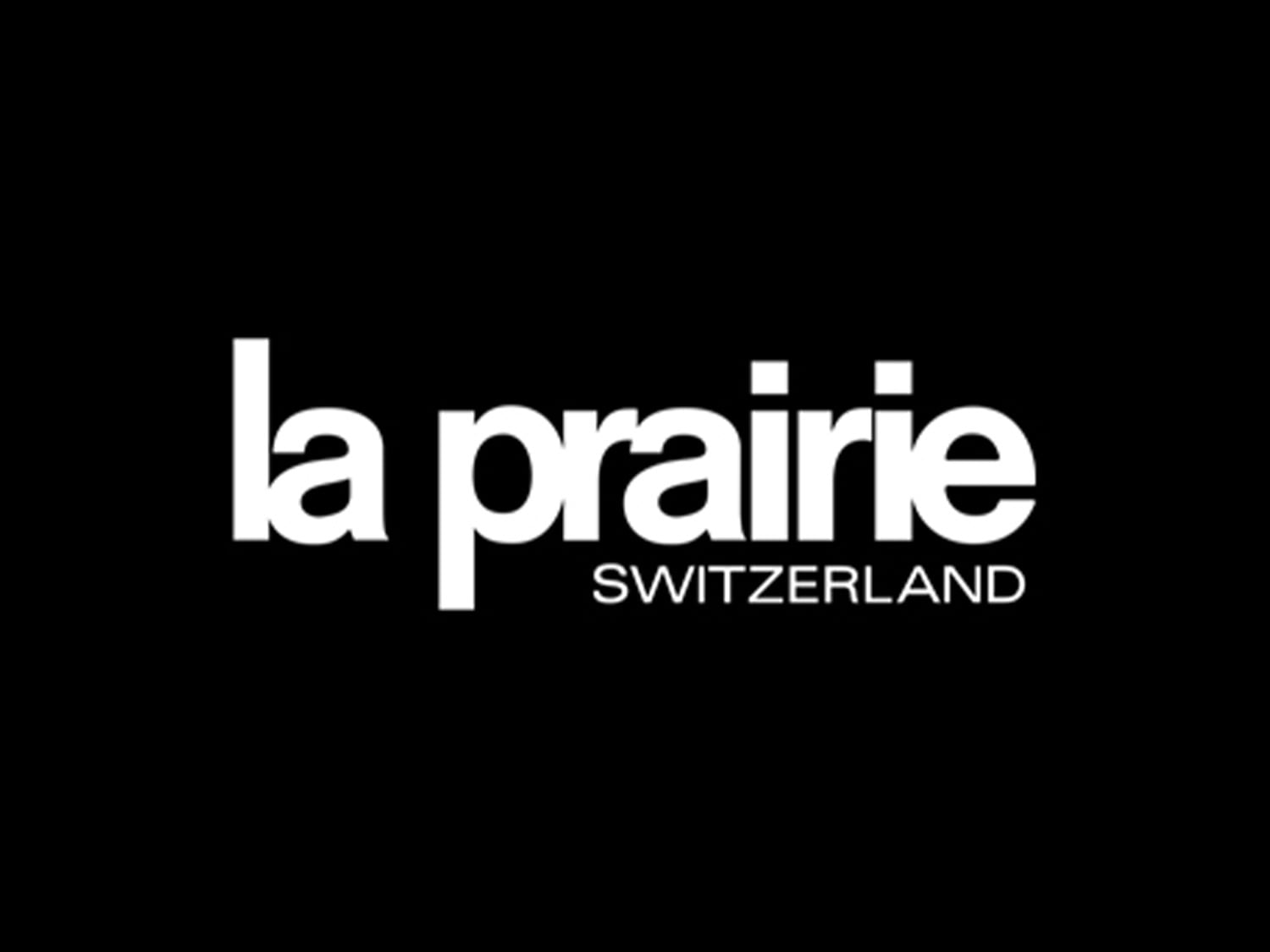 Das La Prairie Logo in Weiß auf schwarzem Hintergrund, darunter der Schriftzug 'Switzerland'.