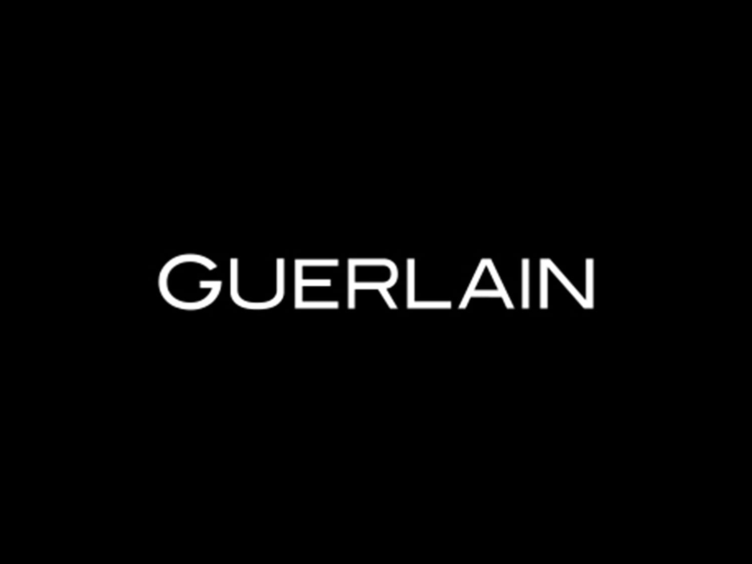 Das Bild zeigt den Schriftzug "GUERLAIN" in weißer Schrift auf einem schwarzen Hintergrund.