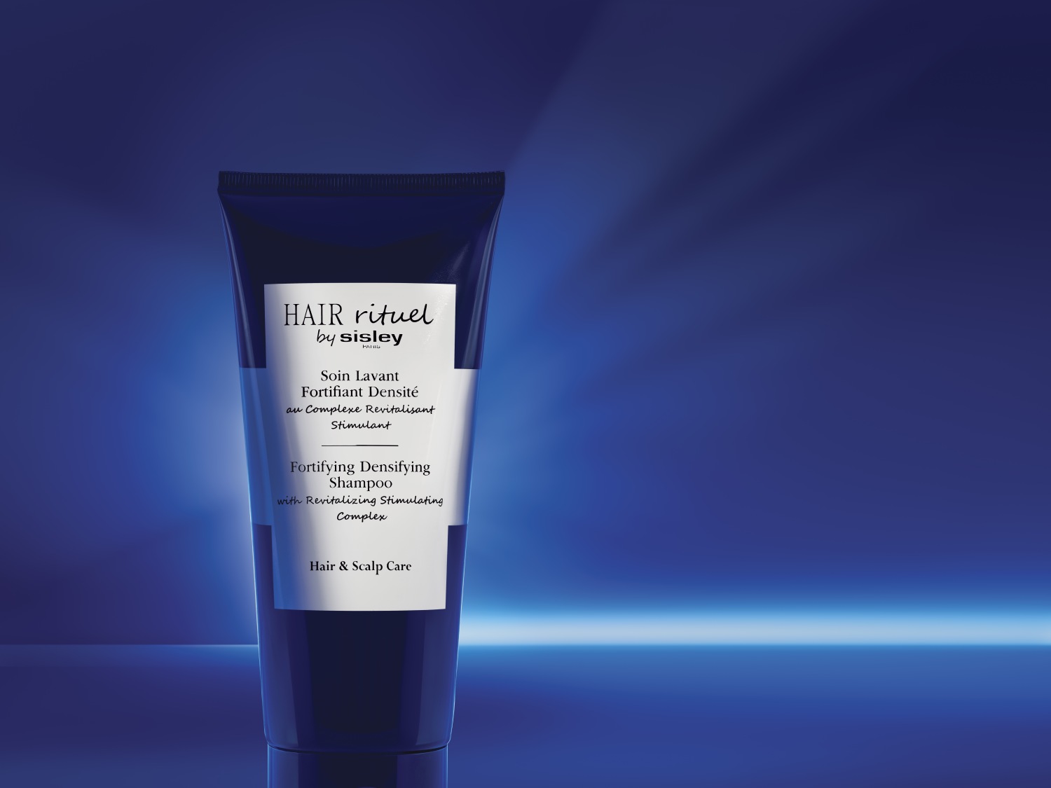 Granatowa tuba szamponu Hair Rituel by Sisley Fortifying Densifying Shampoo, który wzmacnia i dodaje gęstości włosom, z kompleksem rewitalizująco-stymulującym, przeznaczony do pielęgnacji włosów i skóry głowy.