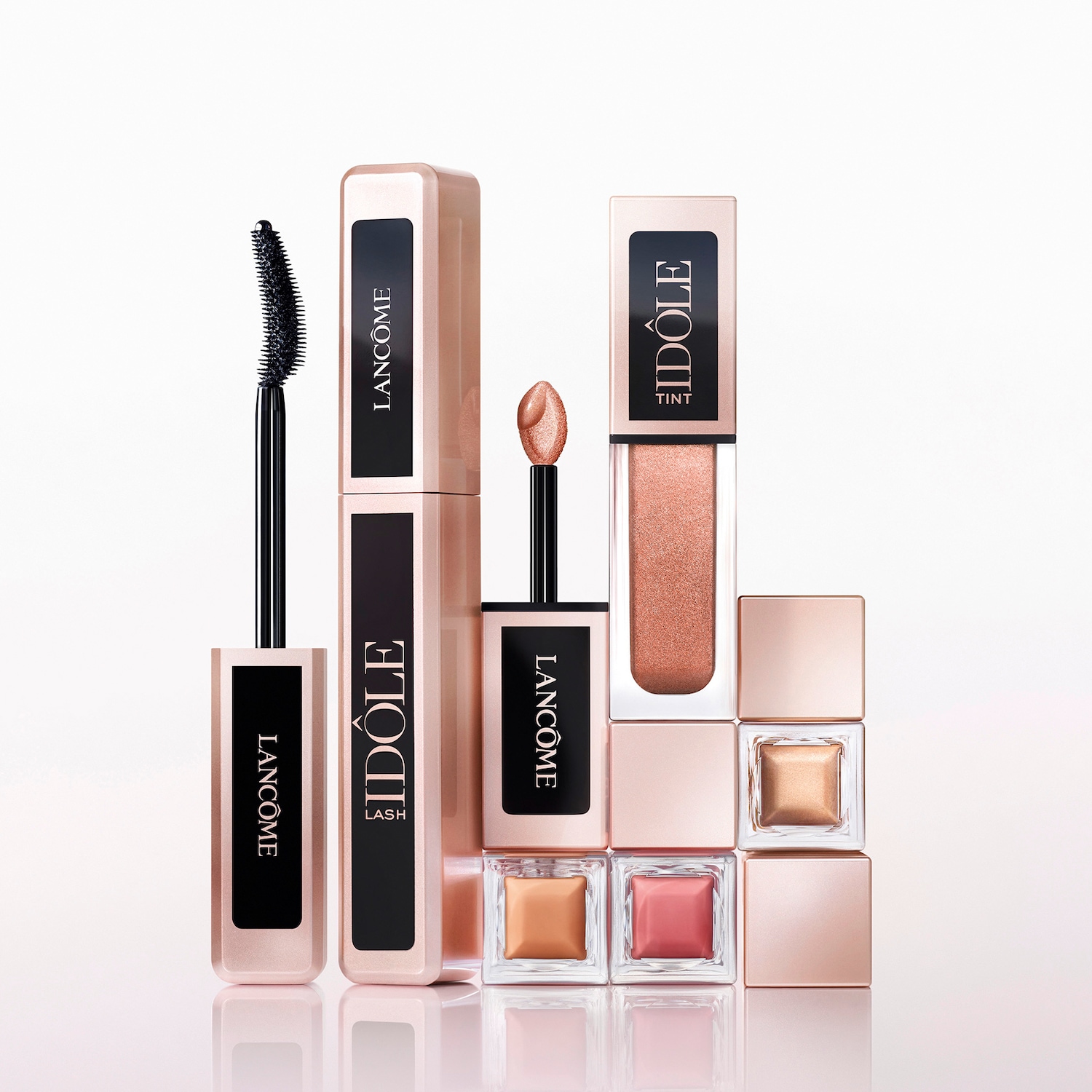 Eine Kollektion von Lancôme Idôle Make-up-Produkten in Roségold-Verpackung, darunter Mascara, Tönung und Lidschatten.