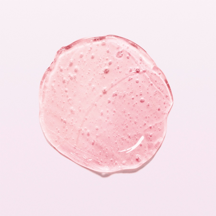 Nahaufnahme eines transparenten, rosafarbenen Gels mit kleinen Bläschen, das eine feuchtigkeitsspendende und erfrischende Textur für die Hautpflege bietet.