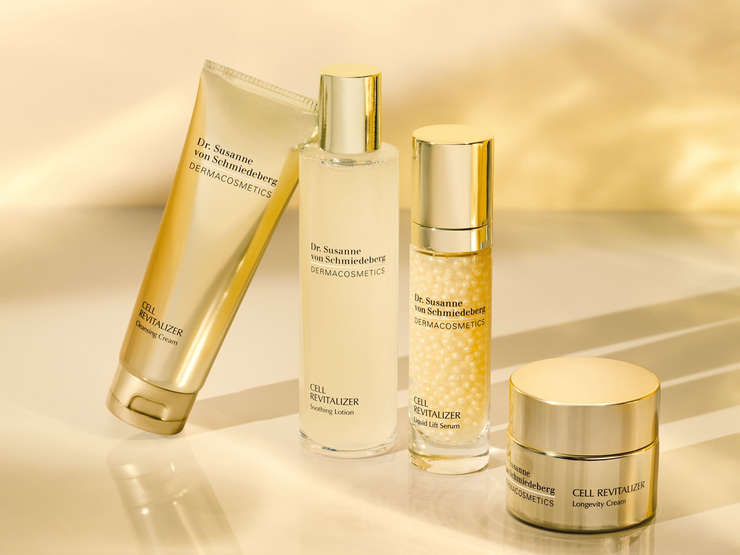 Kolekcja Dr. Susanne von Schmiedeberg DERMACOSMETICS w złotych opakowaniach: krem oczyszczający, tonik łagodzący, serum liftingujące i krem na długowieczność.