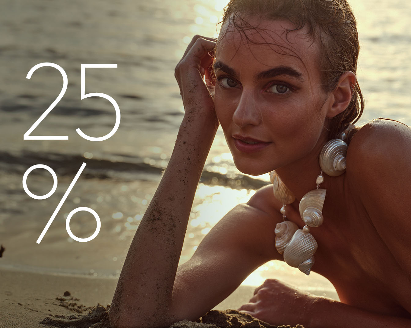 Kobieta leży na plaży w muszelkowym naszyjniku, a obok niej widnieje napis 25%, co sugeruje promocję lub zniżkę.
