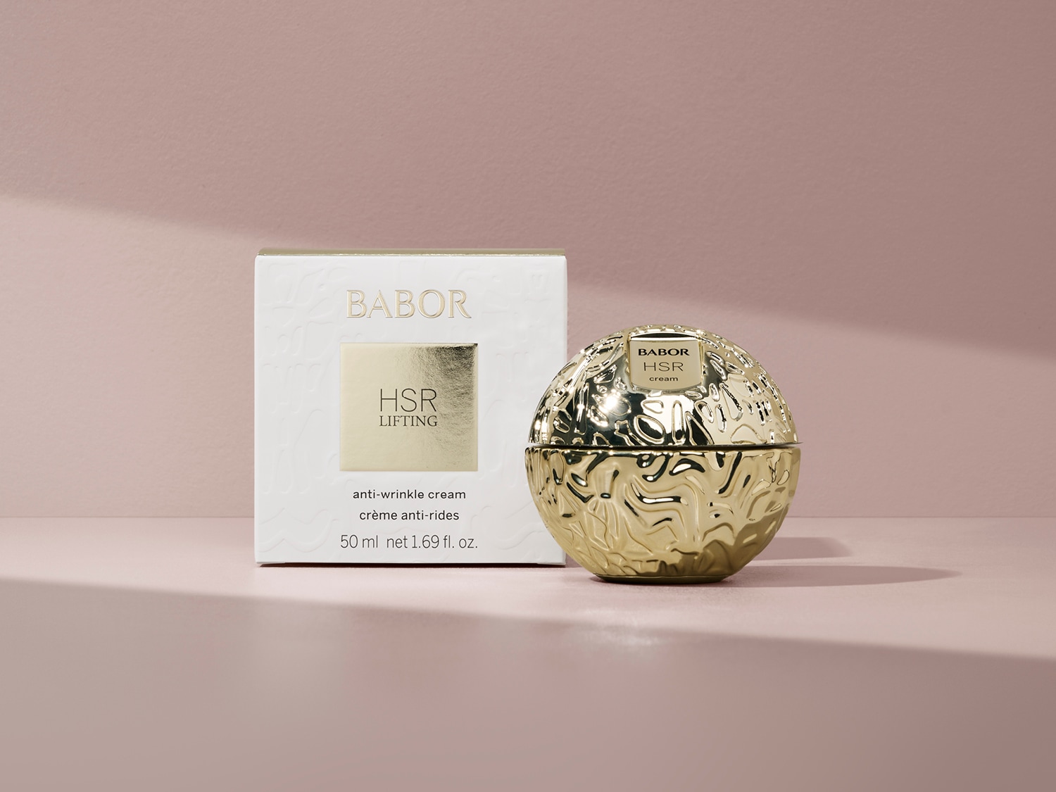 Babor HSR Lifting, krem przeciwzmarszczkowy w złotym opakowaniu w kształcie kuli, obok białego pudełka z napisem HSR Lifting.