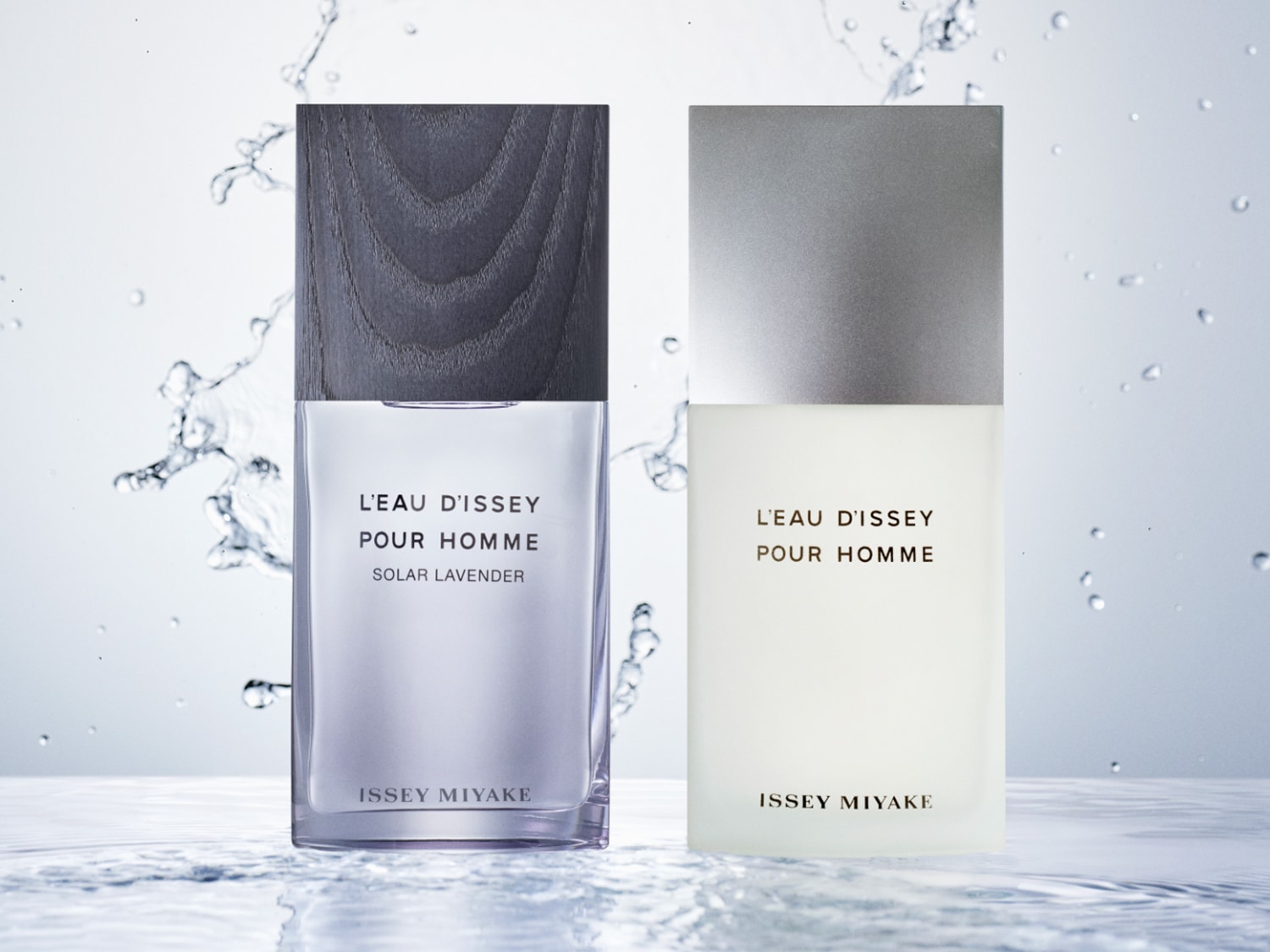 Dos frascos de perfume L'Eau d'Issey Pour Homme, uno con tapa de madera grisácea y líquido lavanda, el otro con tapa plateada y líquido blanco, ambos sobre un fondo acuático.