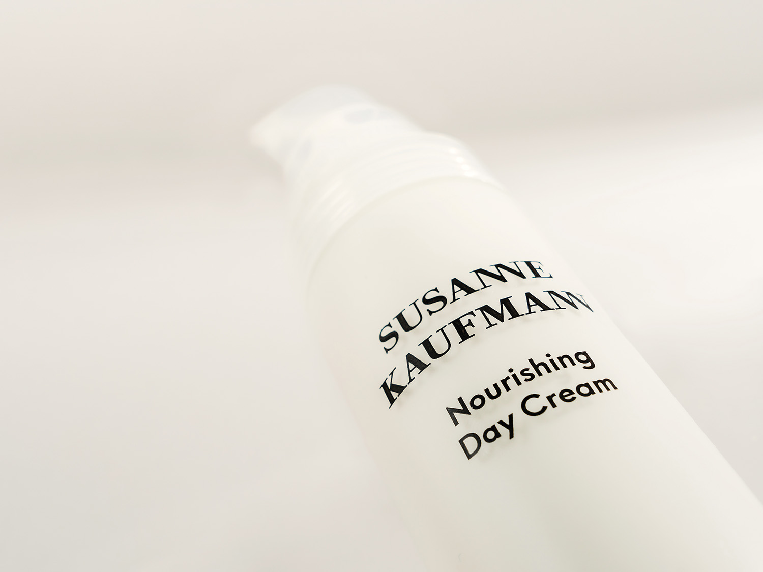 Nahaufnahme einer weißen Flasche Susanne Kaufmann Nourishing Day Cream mit schwarzer Schrift, die ein elegantes und minimalistisches Design zeigt.