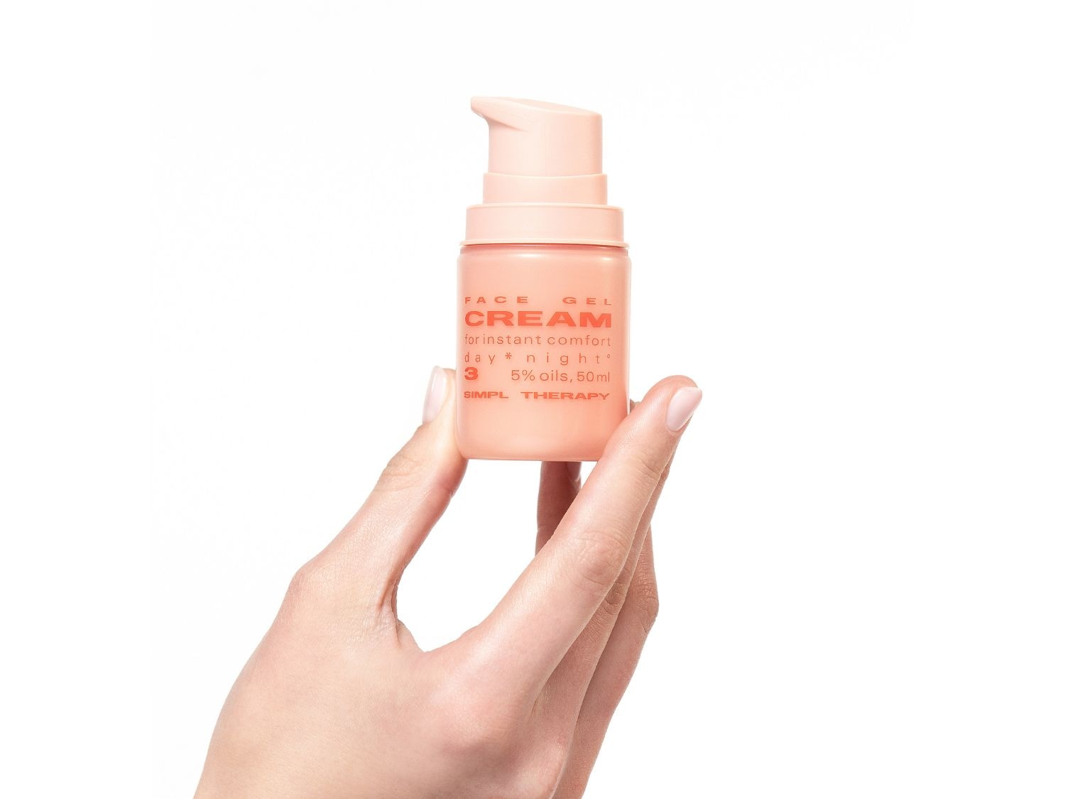 Egy kézben egy barack színű SIMPL THERAPY arckrém, mely azonnali komfortot nyújt nappal és éjszaka, 5%-os olajtartalommal, 50 ml-es kiszerelésben.