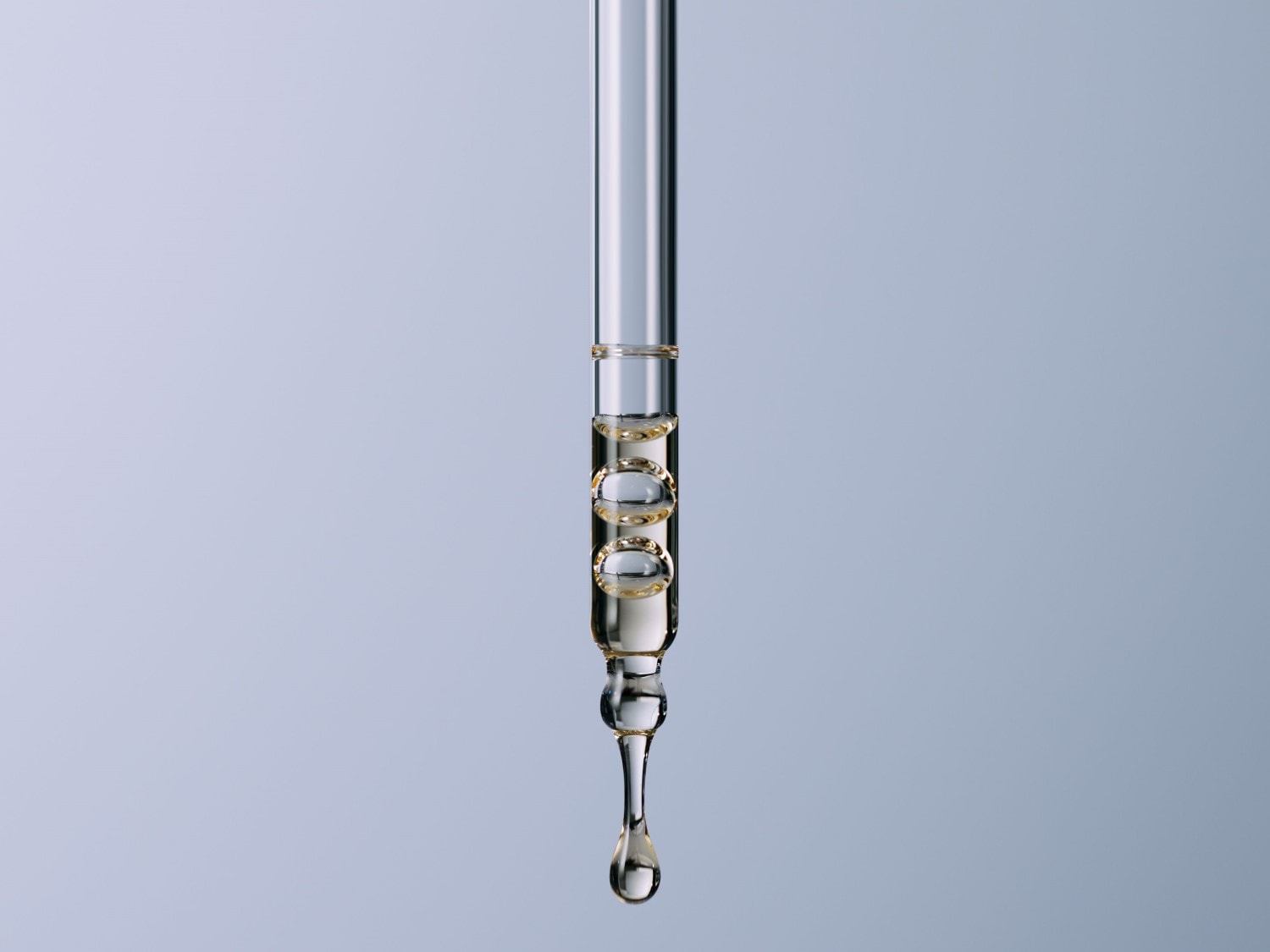 Nahaufnahme einer Pipette mit goldenem Serum, das in Tropfen austritt, ideal für die Anwendung von Hautpflegeprodukten.