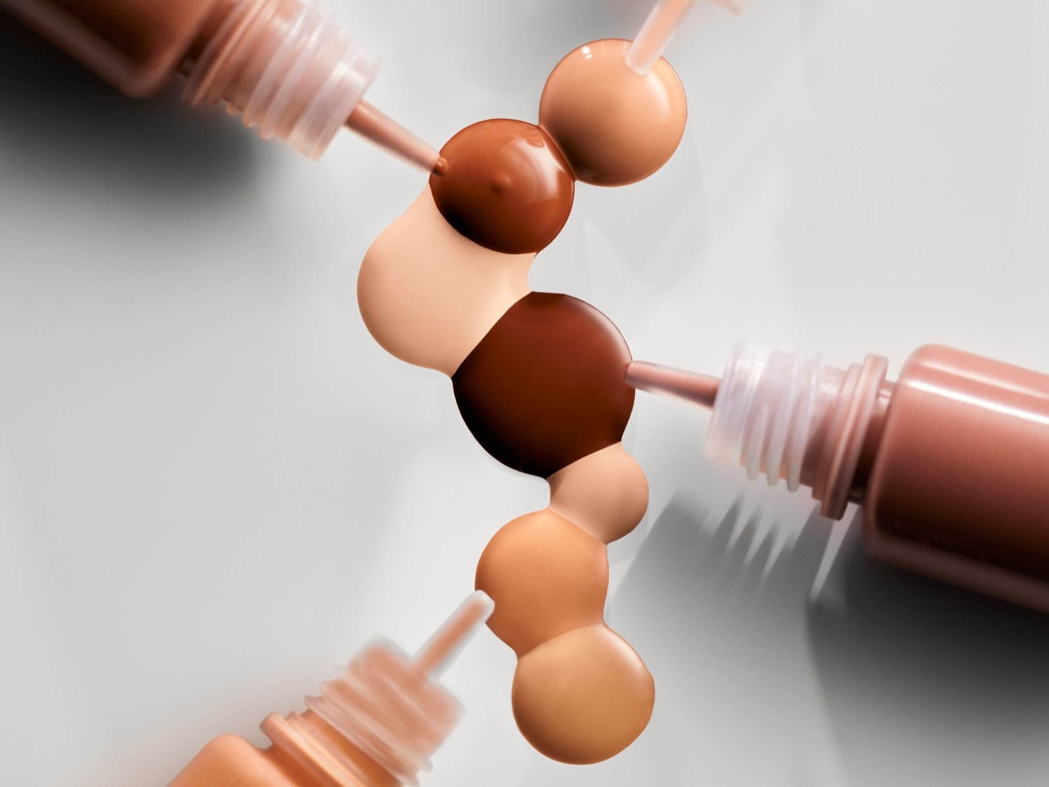 Verschillende tinten foundation worden gemengd, variërend van lichtbeige tot diepbruin, om de perfecte match te creëren.