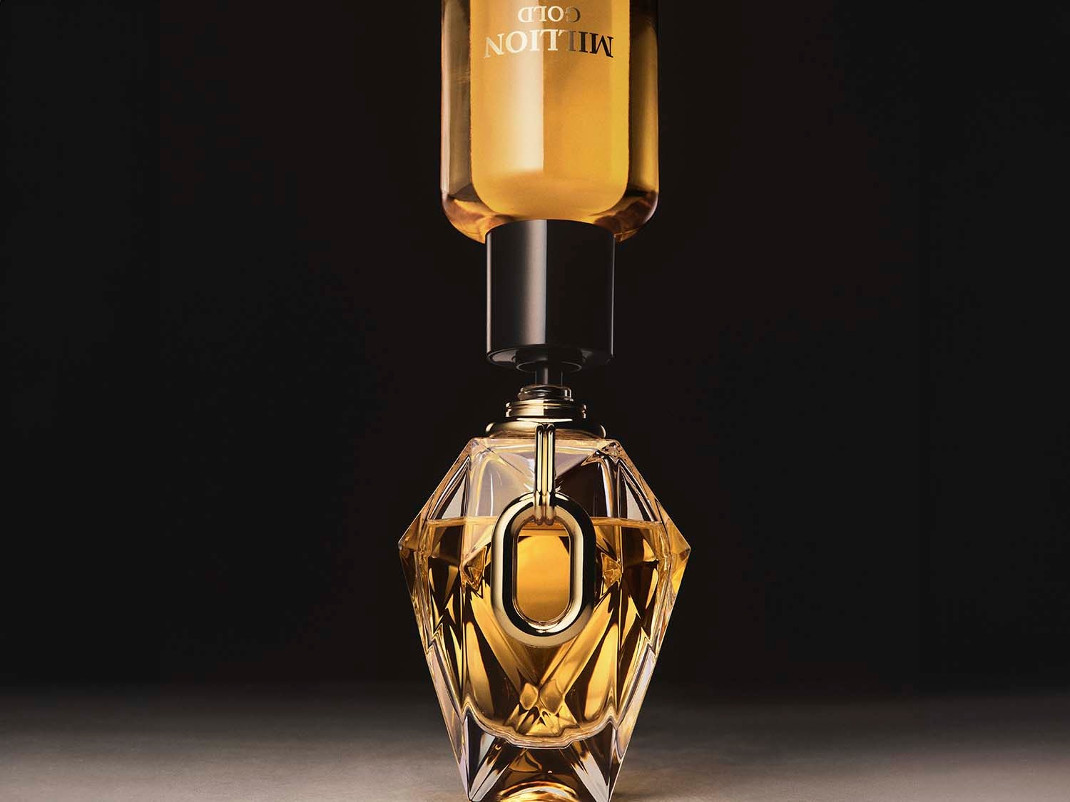 Nahaufnahme eines Flakons Million Gold Parfüm, der mit einer schwarzen Kappe und einem goldenen Verschluss verziert ist, der einen luxuriösen und raffinierten Duft verspricht.