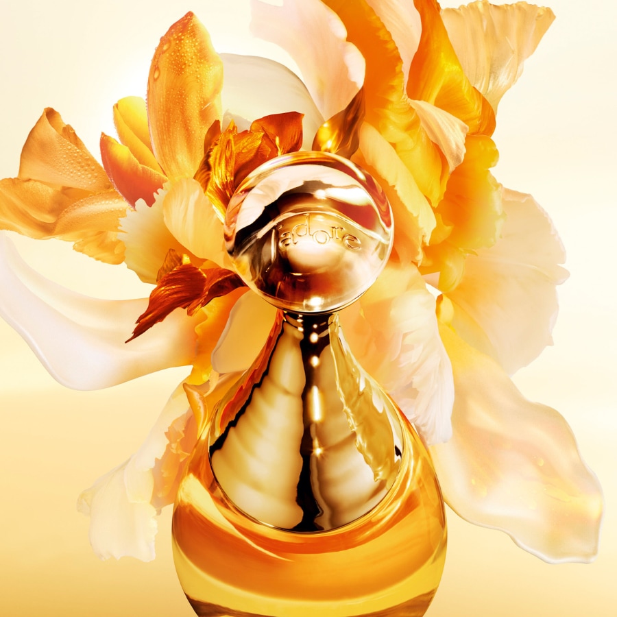 Découvrez J'adore, le parfum emblématique de Dior, dans un flacon doré étincelant, sublimé par des fleurs délicates aux tons chauds.