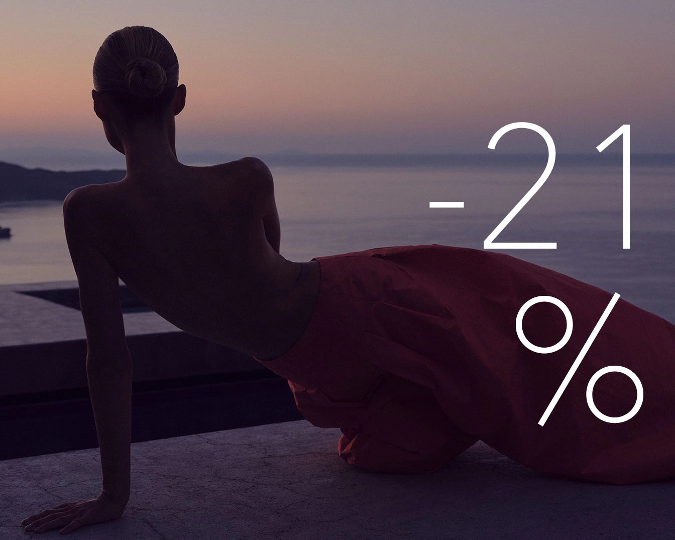 Na tle zachodzącego słońca, sylwetka kobiety w czerwonej sukni i napis -21% zwiastują atrakcyjną promocję.