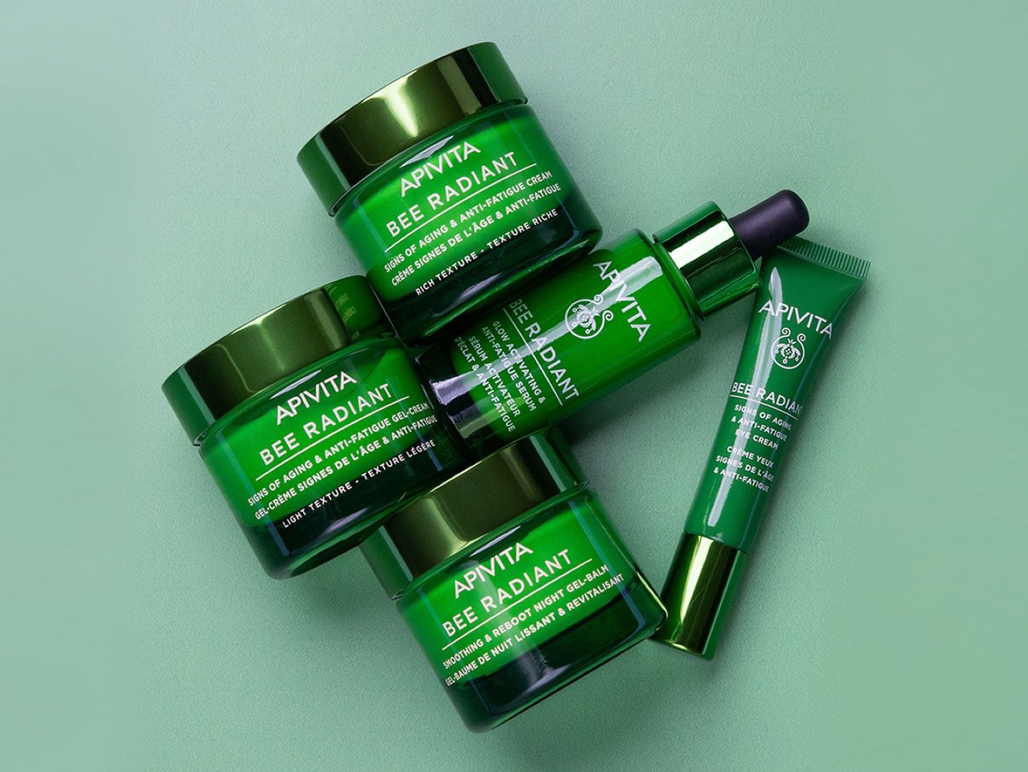 Descubre la línea Bee Radiant de Apivita, que incluye crema, sérum y bálsamo en envases verdes, diseñados para combatir los signos del envejecimiento y la fatiga.