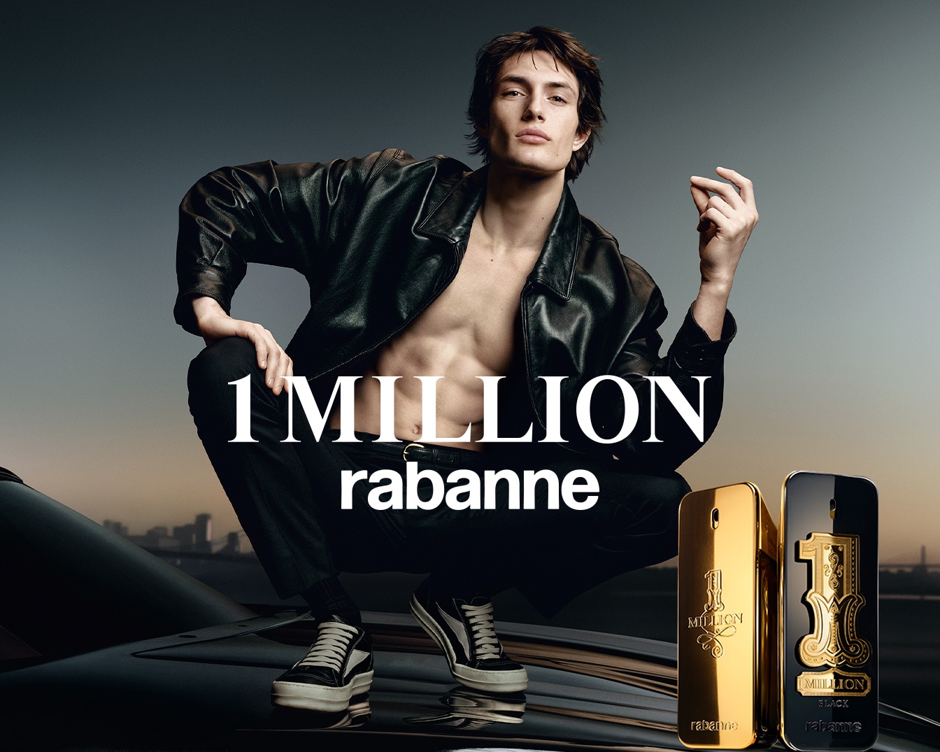 Un hombre con chaqueta de cuero negra y el torso desnudo se agacha sobre un coche negro, con dos frascos de perfume 1 Million de Rabanne, uno dorado y otro negro, en primer plano.