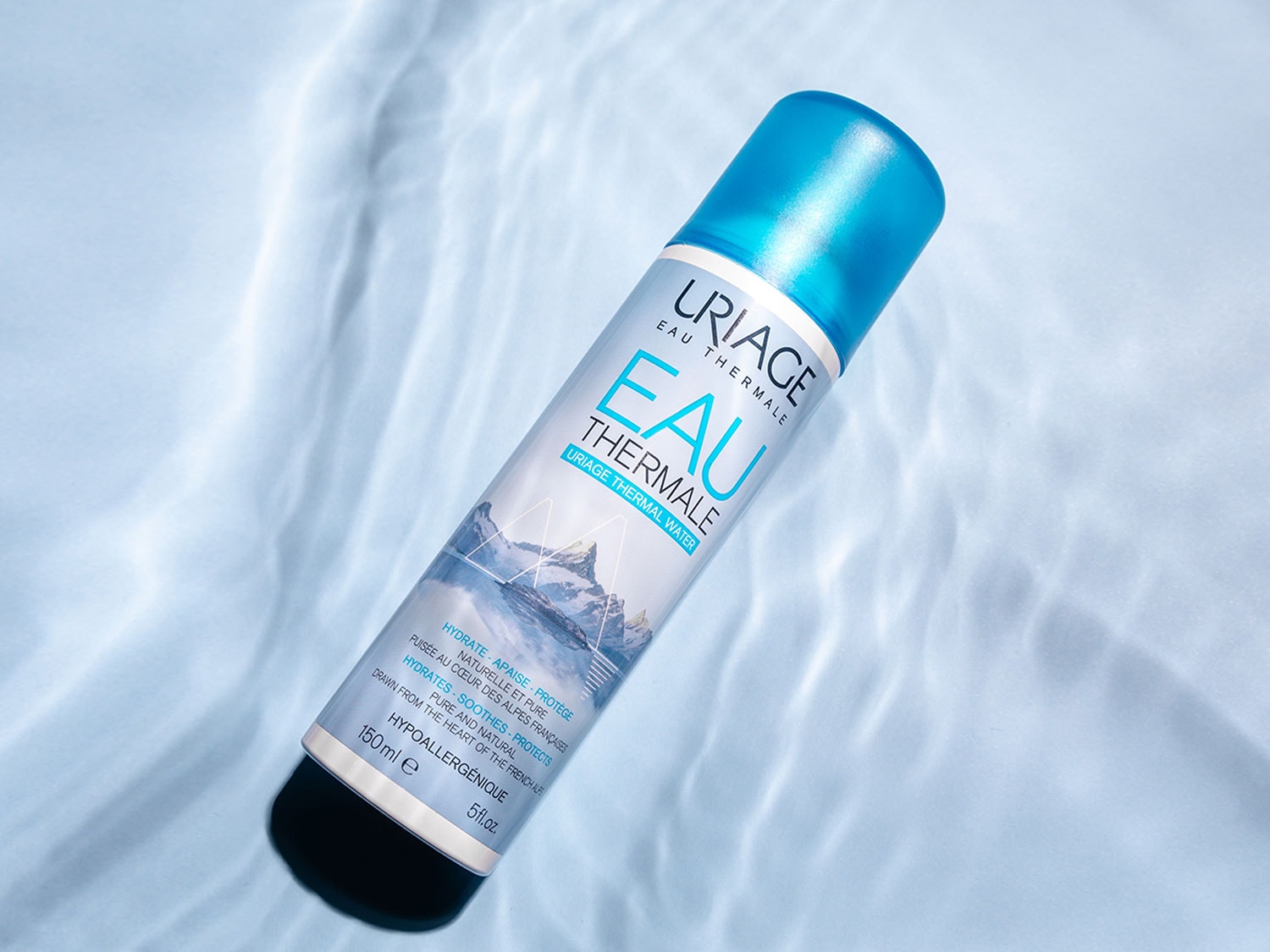 Aquí tienes un spray de agua termal Uriage, con un envase cilíndrico blanco y letras azules, ideal para hidratar, calmar y proteger tu piel.