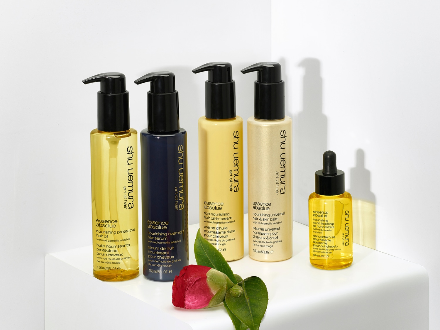 Kolekcia vlasovej kozmetiky Shu Uemura Essence Absolue s olejmi v rôznych baleniach, od žltých olejov až po nočné séra v tmavomodrých fľaštičkách.