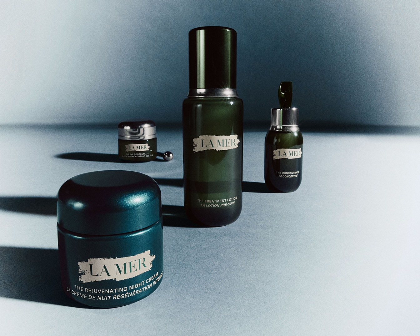 Ontdek de La Mer collectie: een verzorgende nachtcrème, een herstellende lotion, een geconcentreerd serum en een oogcontourcrème, allemaal verpakt in elegante, donkergroene flacons.