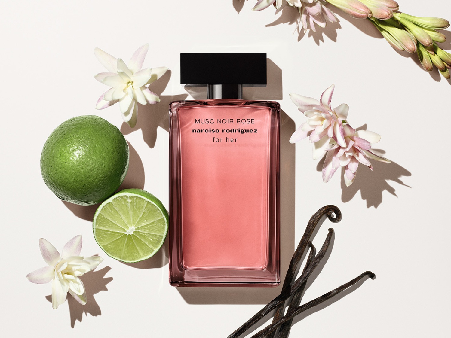 Découvrez le parfum Musc Noir Rose de Narciso Rodriguez for Her, un parfum floral et musqué présenté dans un élégant flacon rose, entouré de fleurs délicates, de limes fraîches et de gousses de vanille.