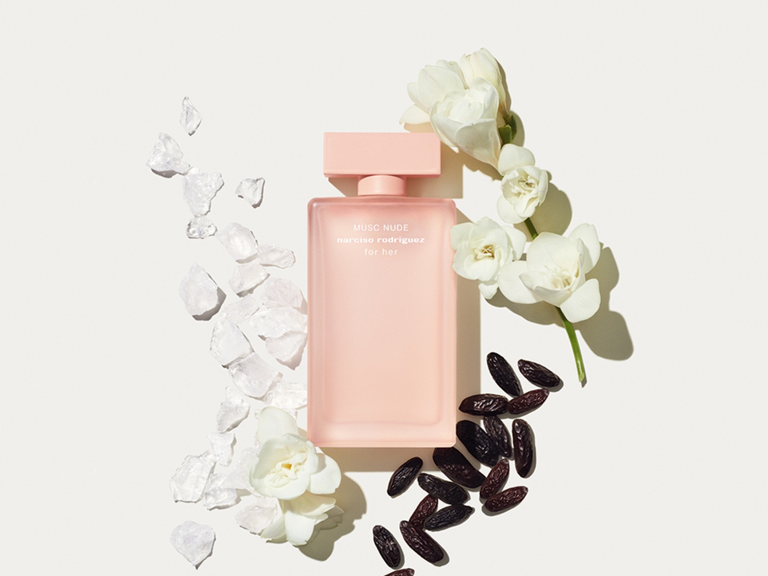 Découvrez Musc Nude de Narciso Rodriguez for her, un parfum délicat dans un flacon rose poudré, entouré de fleurs blanches, de cristaux et de fèves sombres.