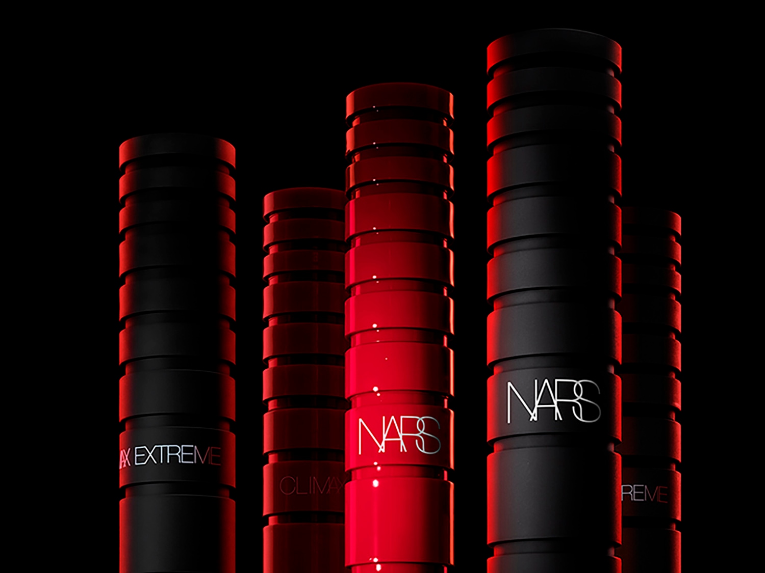 Aquí hay una colección de máscaras NARS en envases negros y rojos, cada una con un diseño cilíndrico acanalado y el logo de NARS en el centro.