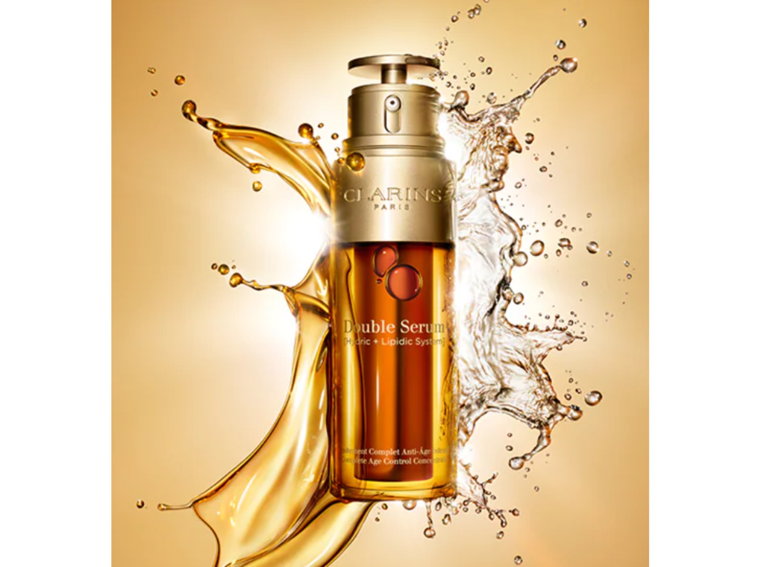 Bursztynowa butelka Clarins Double Serum otoczona jest rozpryskami złocistego płynu i wody, co podkreśla luksusowy i nawilżający charakter produktu.