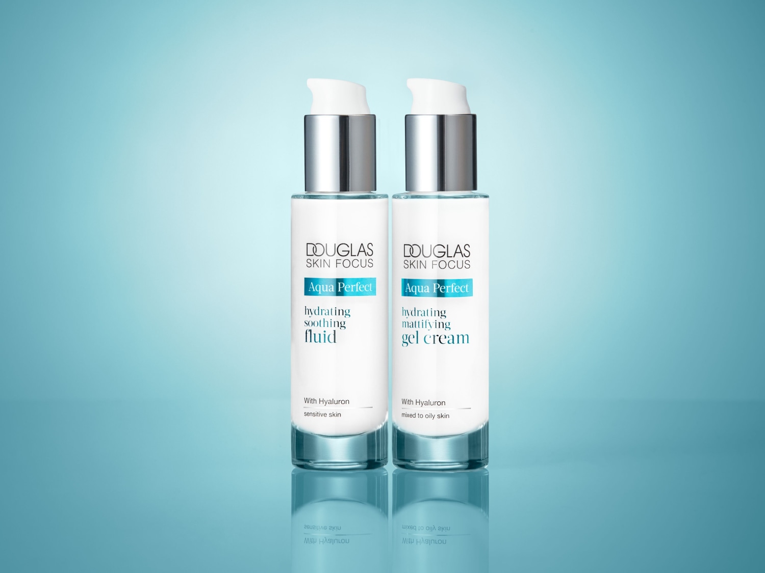 Dwa białe flakony Douglas Skin Focus Aqua Perfect: nawilżający, kojący fluid do skóry wrażliwej i matujący krem-żel do cery mieszanej i tłustej, oba z dozownikiem i napisem With Hyaluron.