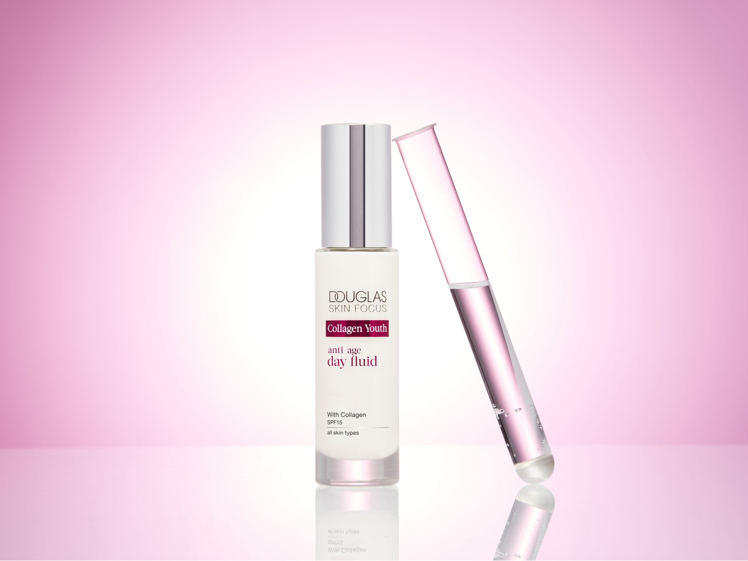 Douglas Skin Focus Collagen Youth anti-age day fluid w białej butelce z srebrną nakrętką, obok probówka z płynem na tle różowego gradientu.