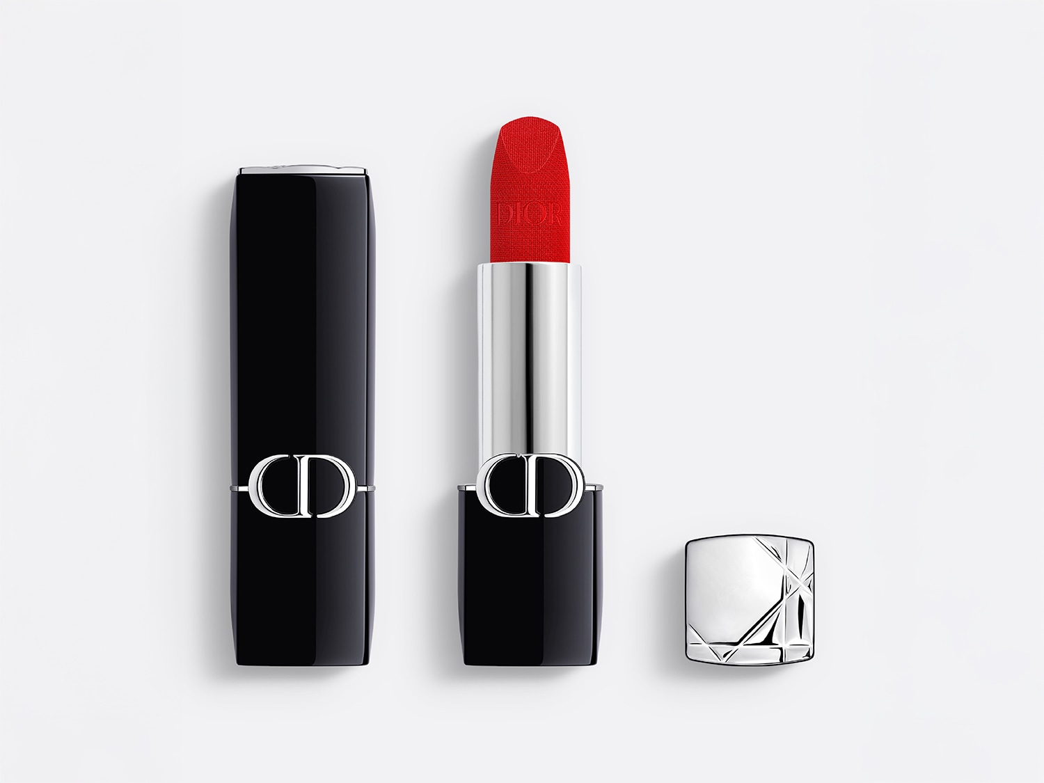 Ryškiai raudonas „Dior“ lūpų dažas su juodu korpusu ir sidabriniais akcentais, atspalvis intensyvus ir sodrus.