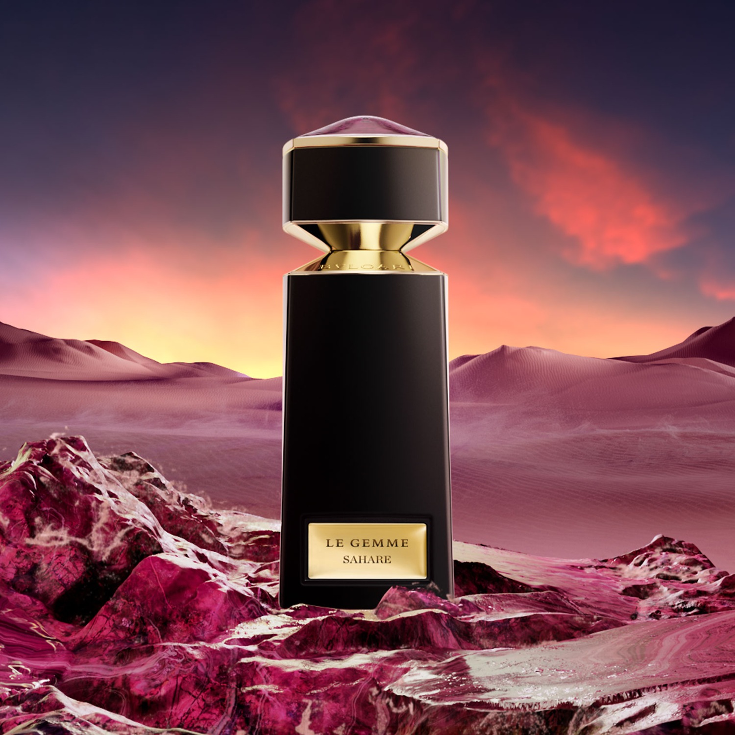 Eine schwarze Parfümflasche von Bvlgari Le Gemme Sahare mit goldenen Akzenten steht vor einer Wüstenlandschaft bei Sonnenuntergang.