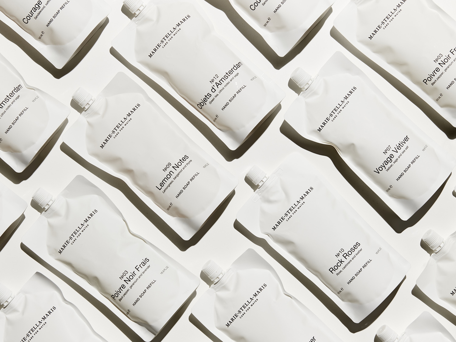 Een verzameling witte hervulverpakkingen van Marie-Stella-Maris handzeep met verschillende geuren, zoals Lemon Notes en Poivre Noir Frais.