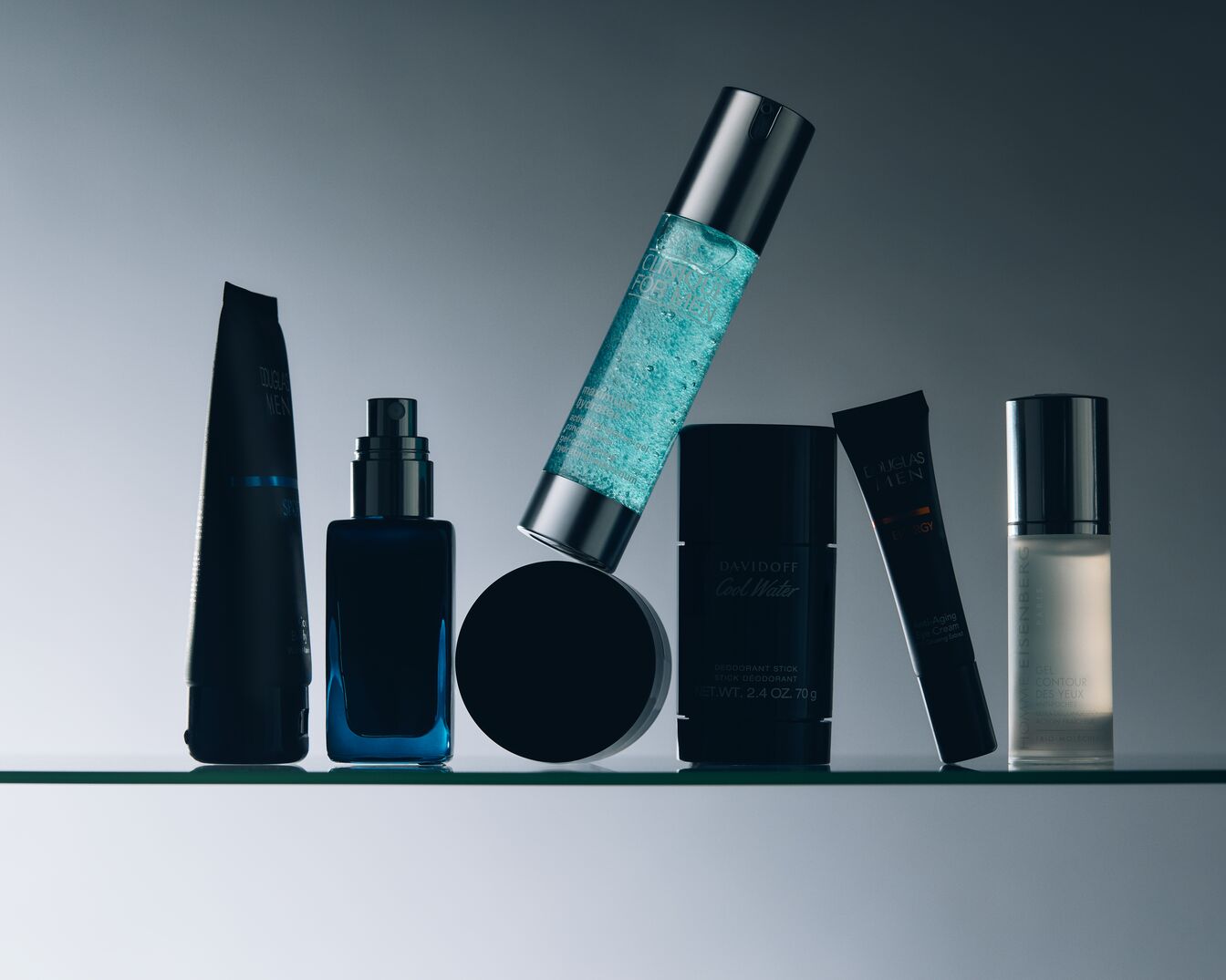 Eine Auswahl an Herrenpflegeprodukten, darunter Davidoff Cool Water Deodorant Stick, Douglas Men Energie Anti-Aging Augencreme und Isenberg Gel Contour Des Yeux.