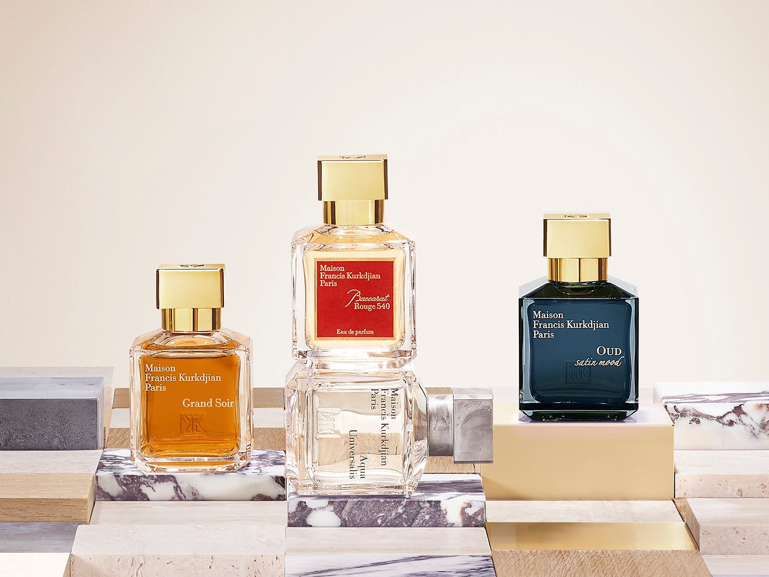 Eine Kollektion von Maison Francis Kurkdjian Paris Düften, darunter Grand Soir, Baccarat Rouge 540 und Oud Satin Mood, präsentiert in eleganten Glasflakons mit goldenen Akzenten.