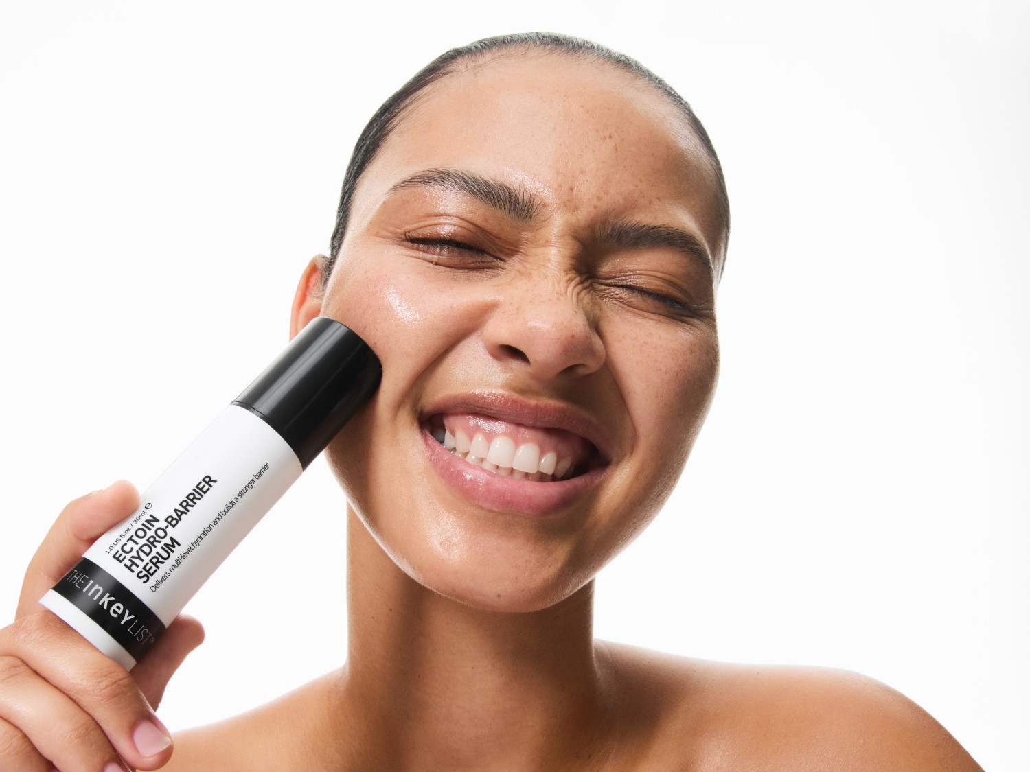 A nő a The INKEY List Ectoin Hydro-Barrier szérumot viszi fel az arcára, amely több szintű hidratálást biztosít és erősebb védőréteget épít.