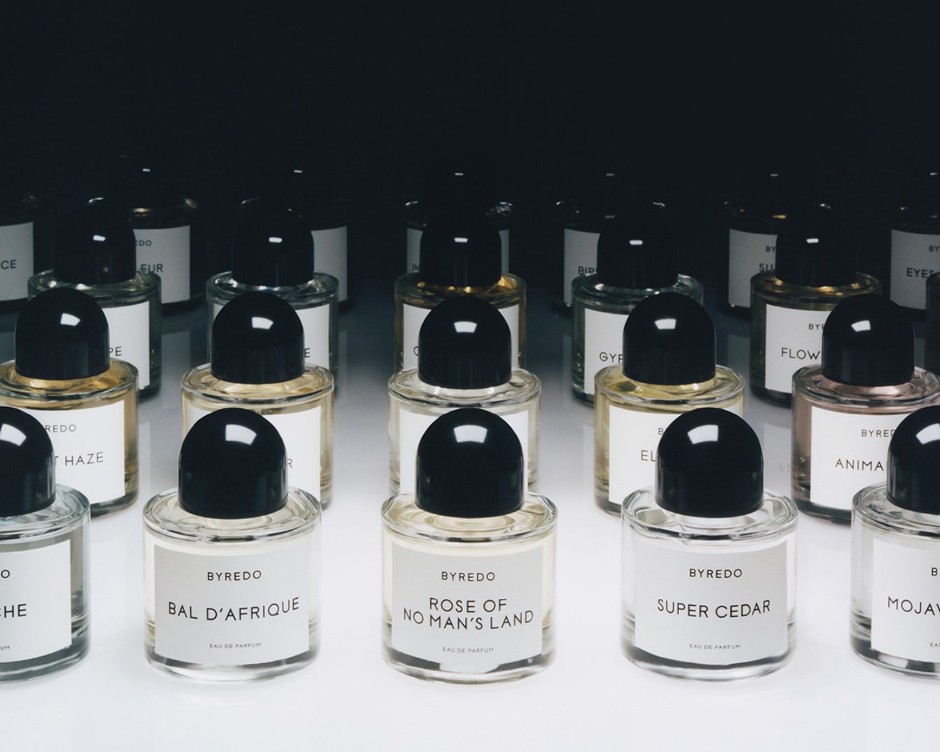Rad fliaš parfumu Byredo s čiernymi vrchnákmi a bielymi štítkami s názvami vôní ako Bal D'Afrique, Rose of No Man's Land a Super Cedar.
