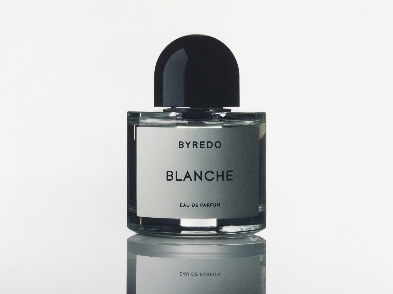 Flakón parfumu Byredo Blanche s čiernym vrchnákom a etiketou s názvom vône na bielom pozadí.